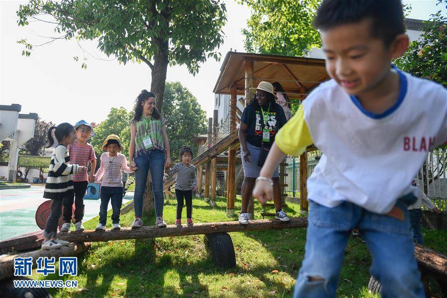 5月14日,外国学前教育工作者在安吉县双一幼儿园与小朋友一起参加游戏