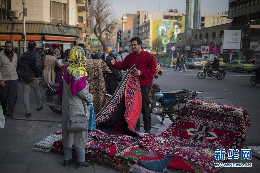 1月20日,在伊朗德黑兰,一名男子在街头售卖毯子.