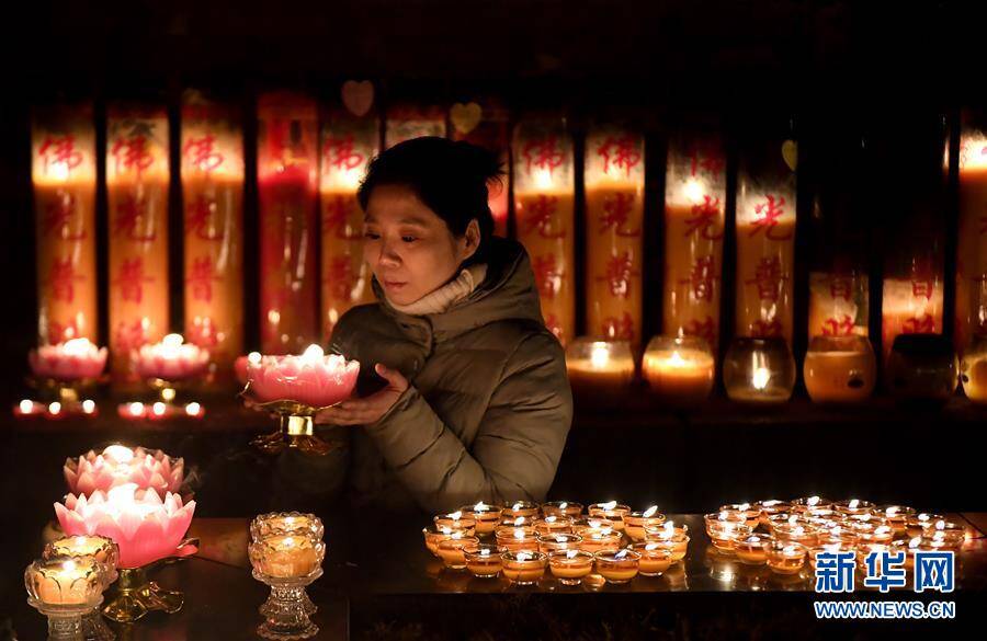 2月12日,市民在西安广仁寺2019新春吉祥祈福灯会上点燃酥油灯.