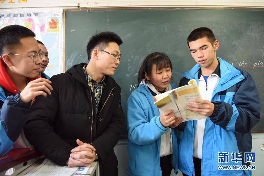 在伊宁市第三中学教室内,援疆教师葛浩浩(中)在指导学生朗诵(12月11日