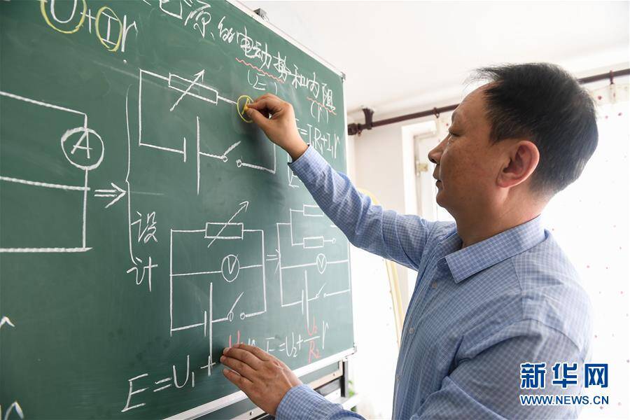 3月5日,呼和浩特市第十六中学高三物理教师呼斯楞在黑板上绘制电路图.