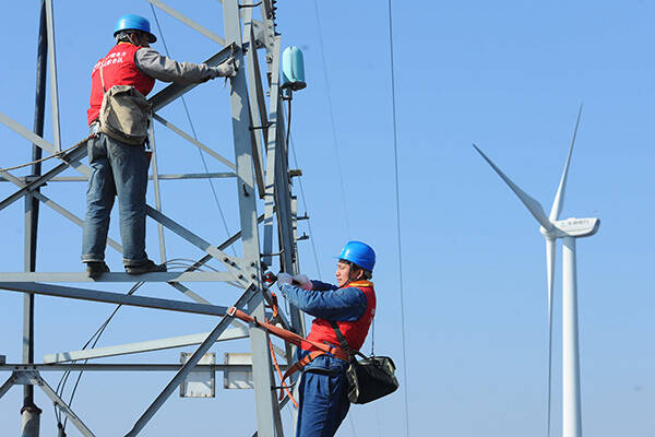 國家電網員工在檢查風力發電設備