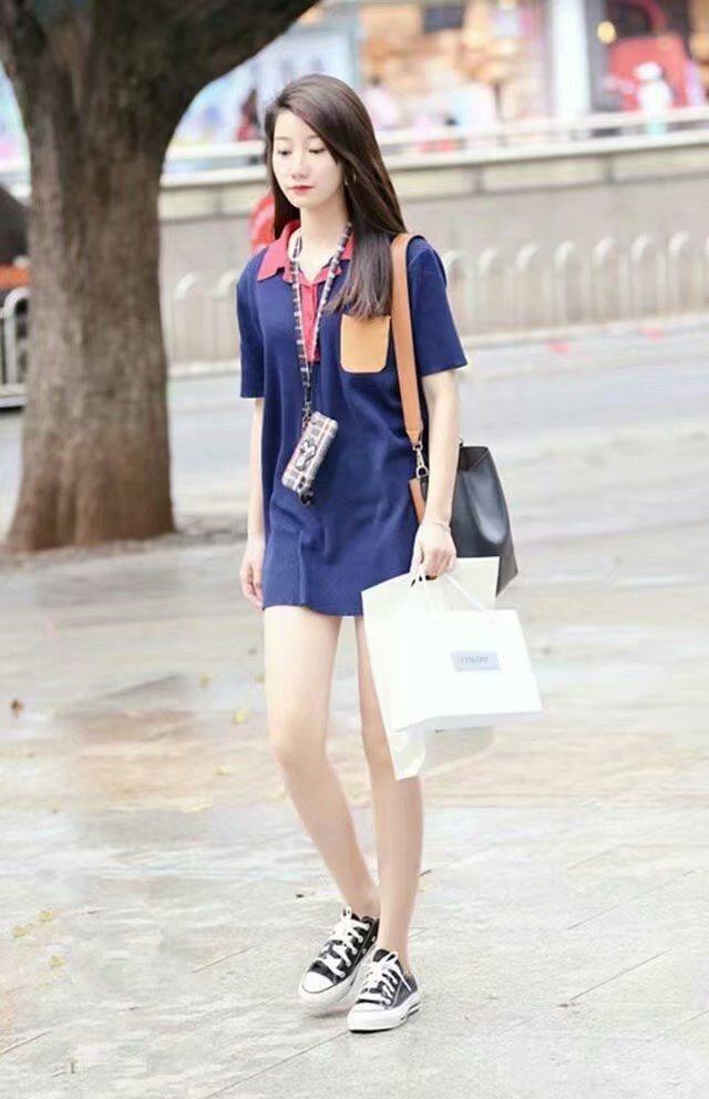 连衣裙搭配一双黑色的平板鞋,美女手上提着好多的东西啊,看来这应该是