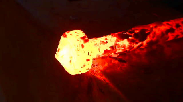 一根铁棒烧红了反复锤打锻造一个可旋转的钩环很纯粹的打铁