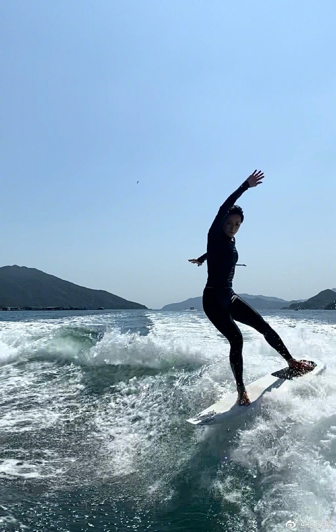 照片中,徐濠萦身穿泳衣,露出大长腿,在海上冲浪,姿势特别酷帅.