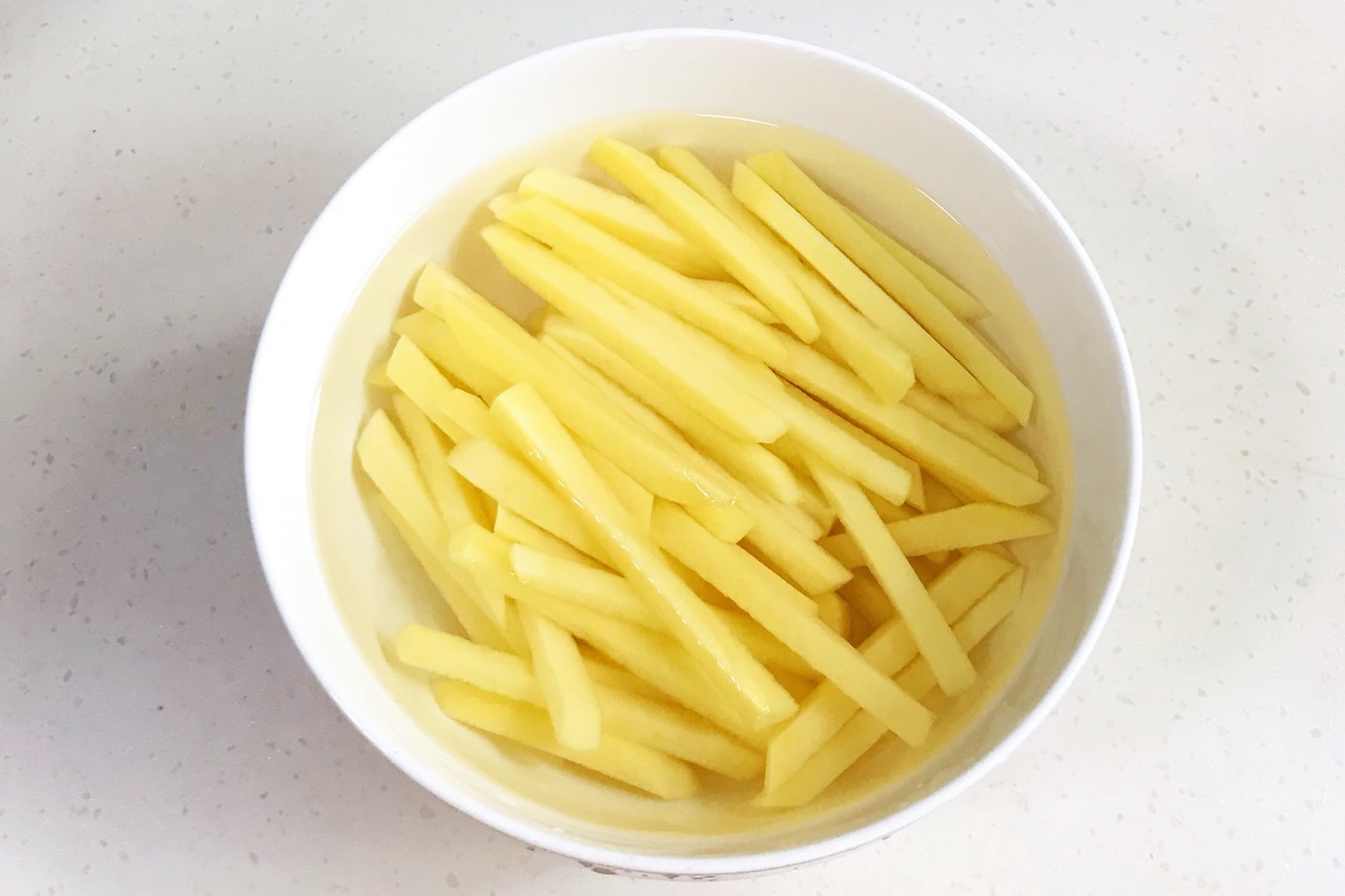 3,切好的土豆条放在凉水里面过一遍凉水,去除表面的淀粉.