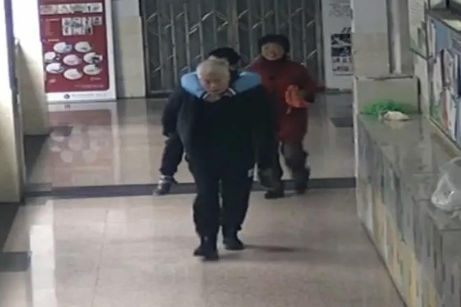 杭师附小校长俞富根雨天背学生进校园