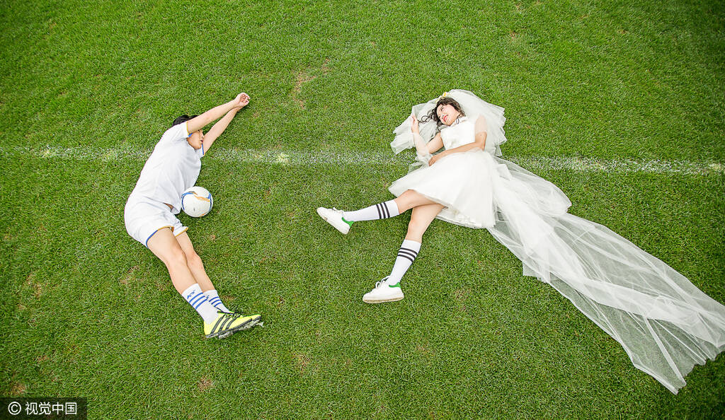 因足球相识相恋情侣球迷拍球场婚纱照