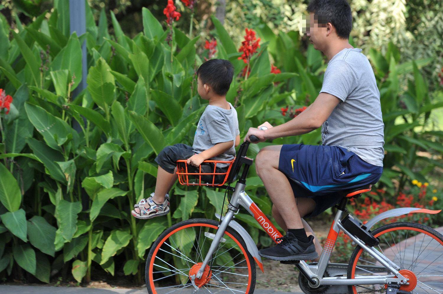单车被"共享",十几岁的孩子坐在车筐上