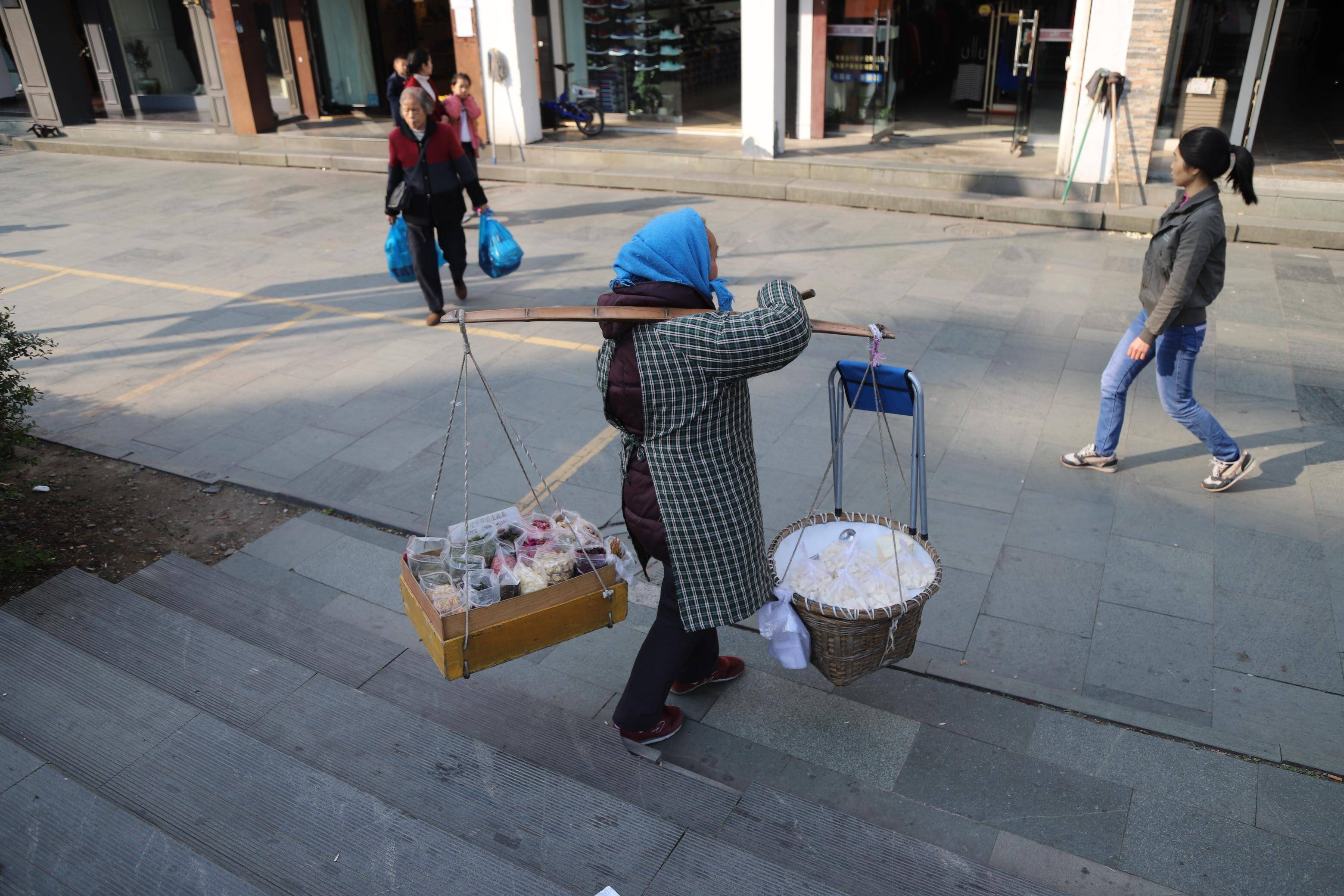 65岁的她白天挑扁担卖糖晚上做酒酿 不给儿子添负担