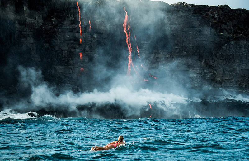 美国女子喷涌火山附近勇敢冲浪