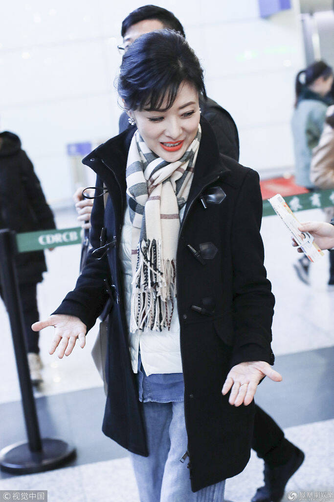 成都,49岁周涛深夜抵达成都机场,她身穿黑色牛角大衣搭配牛仔裤休闲