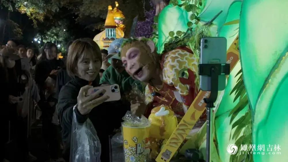 长春动植物公园西游游园活动中，游客与“雪饼猴”互动。