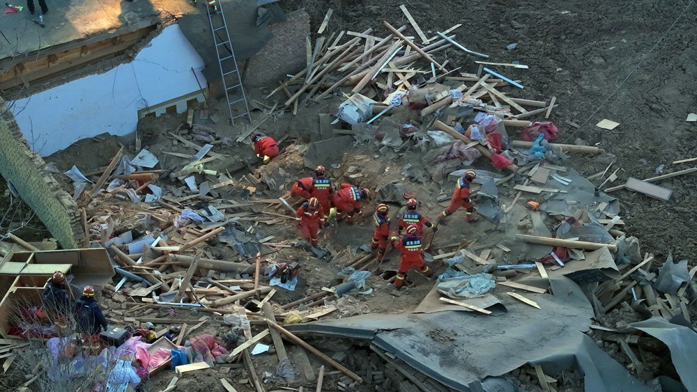 在青海省海东市民和回族土族自治县中川乡草滩村，海东市消防救援支队队员在搜救 图片来源：新华社