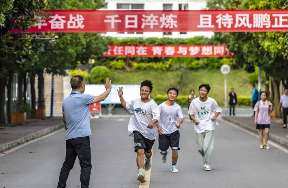 6月7日，在贵州省黔西一中考点，考生与老师击掌鼓劲后奔赴考点。新华社发（范晖摄）