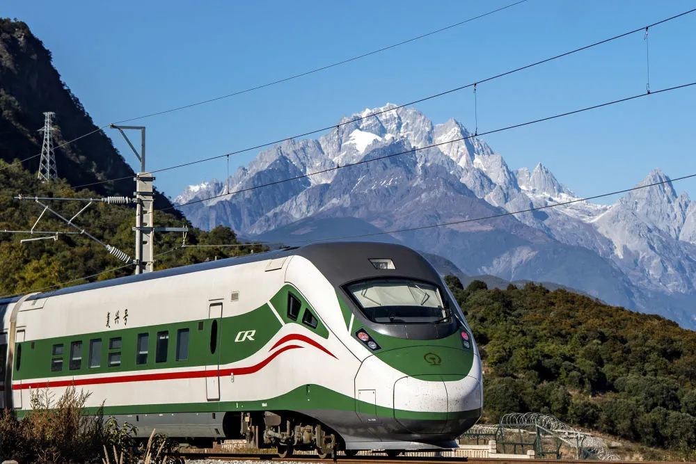 2023年11月26日，列车从玉龙雪山脚下驶过。 新华社记者 胡超 摄