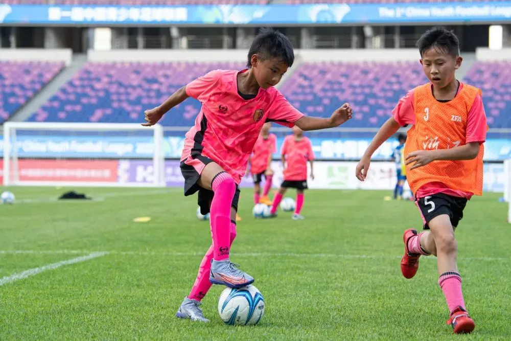 △ 2022年7月10日，小球员们在第一届中国青少年足球联赛启动仪式现场展示小球员青训大纲的训练内容。新华社记者 江汉 摄