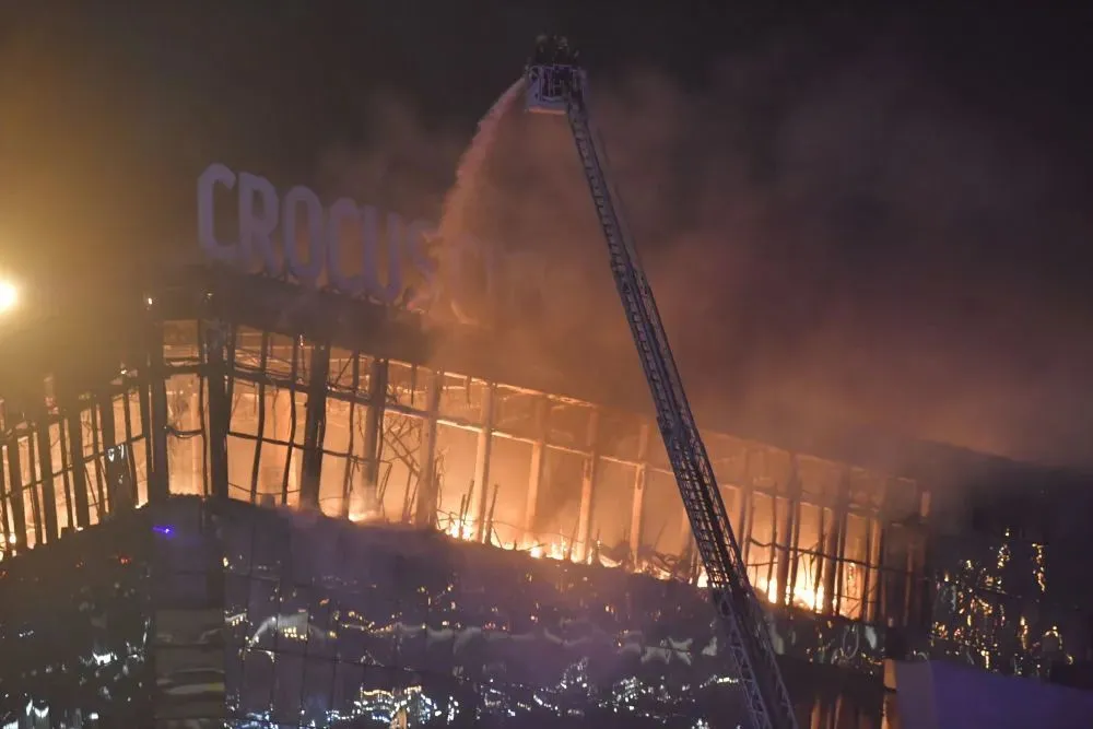 3月22日，在俄罗斯莫斯科近郊克拉斯诺戈尔斯克市，消防人员对发生枪击事件后引发火灾的音乐厅灭火。新华社发（亚历山大摄）