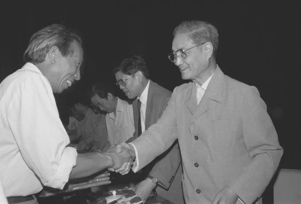 1991年6月26日，中共中央组织部、中共中央宣传部等单位在北京召开大会，表彰全国高校优秀思想政治工作者。这是宋平同志（右）向获奖的个人颁奖。新华社记者 张燕辉 摄