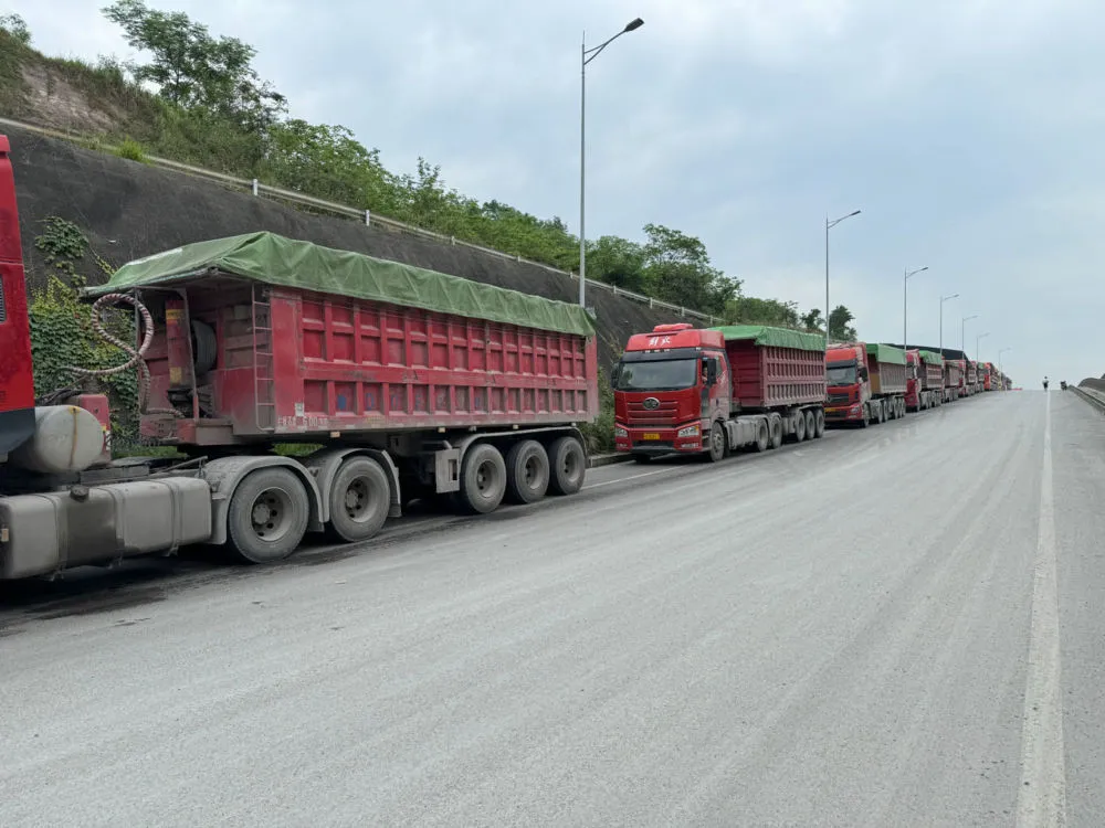 在乌扬公用码头外等待卸货的大货车。记者 程子龙 摄