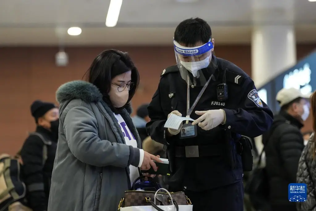 1月24日，沈阳出入境边防检查站民警帮助旅客通关。新华社记者潘昱龙 摄