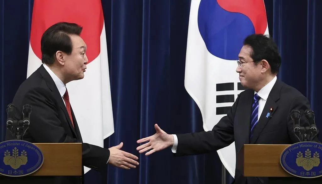 资料图：当地时间2023年3月16日，日本东京，日本首相岸田文雄(右)和韩国总统尹锡悦在首相办公室举行的联合记者招待会结束后握手。 