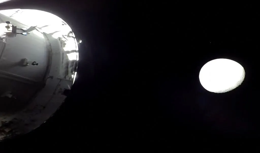 4月6日，美国，来自美国国家航空航天局（NASA）直播的截图显示了猎户座飞船与月球。（视觉中国）