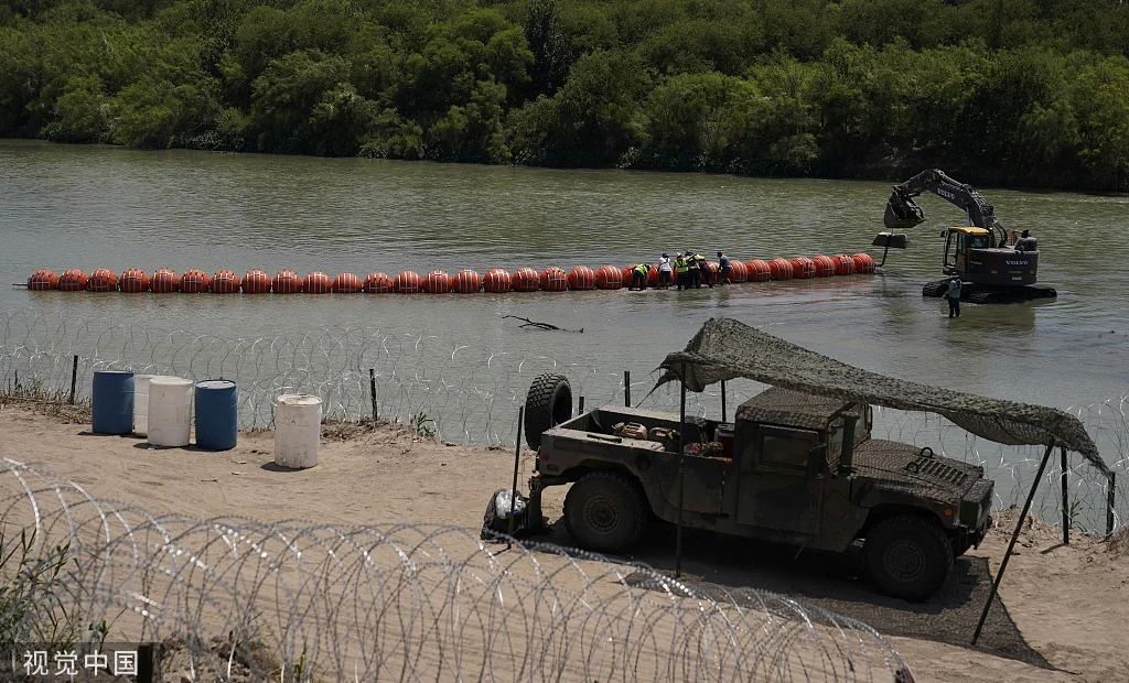 当地时间2023年7月11日，美国得州伊格尔帕斯，工人们在格兰德河沿岸组装大型浮标，作为边界屏障。（视觉中国）