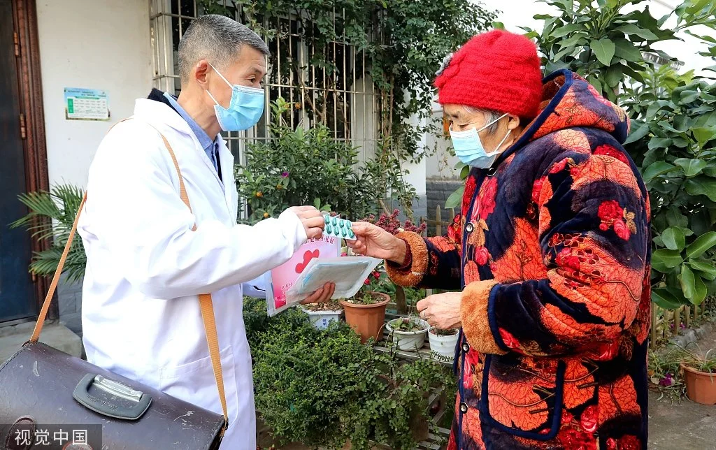 2022年12月29日，四川省眉山市，仁寿县珠嘉镇棚村村的村医生正在指导高龄老人如何服用“健康礼包”的药品。视觉中国 图