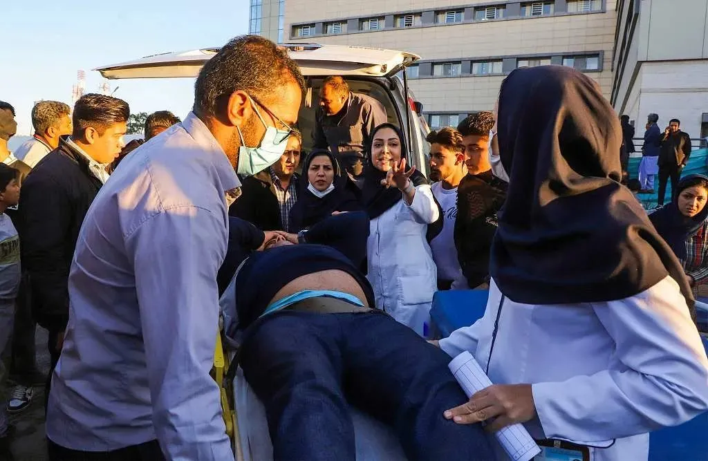 1月3日，伊朗克尔曼，连环爆炸袭击发生后，医护人员抬着一名受伤的男子。