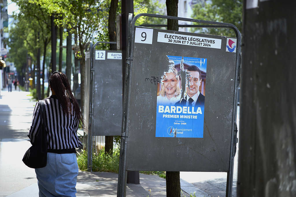 当地时间2024年6月23日，法国巴黎，投票站的选举海报上印着极右翼政党“国民联盟”玛丽娜·勒庞与若尔当·巴尔代拉的照片。（视觉中国）