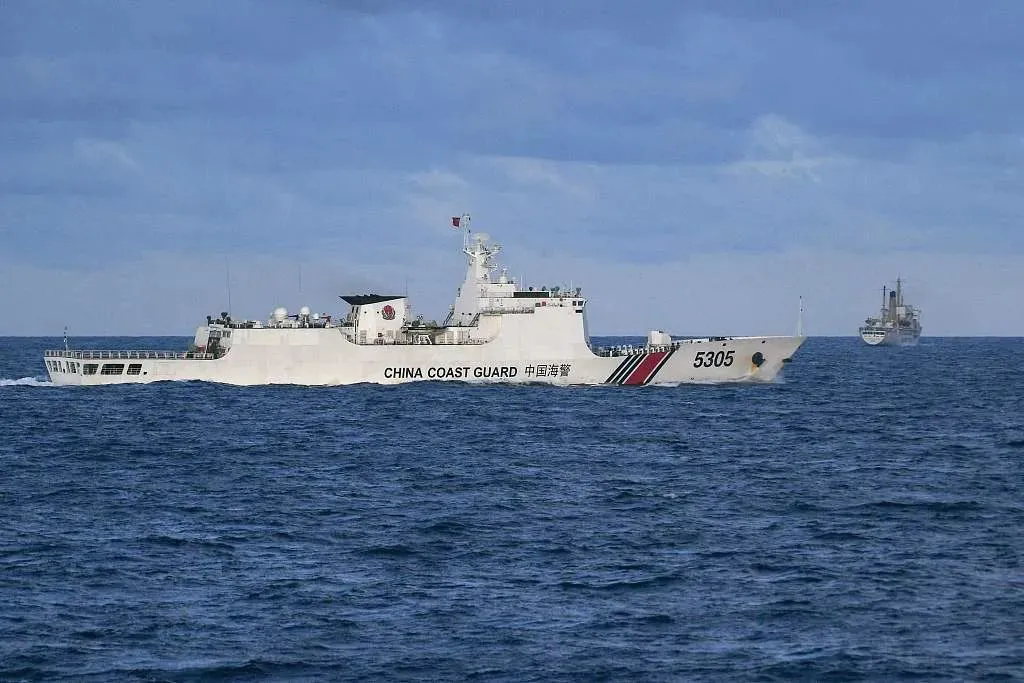 2023年12月10日，在南海，一艘中国海警船驱离一艘菲律宾船只(右)。图源：新华视觉