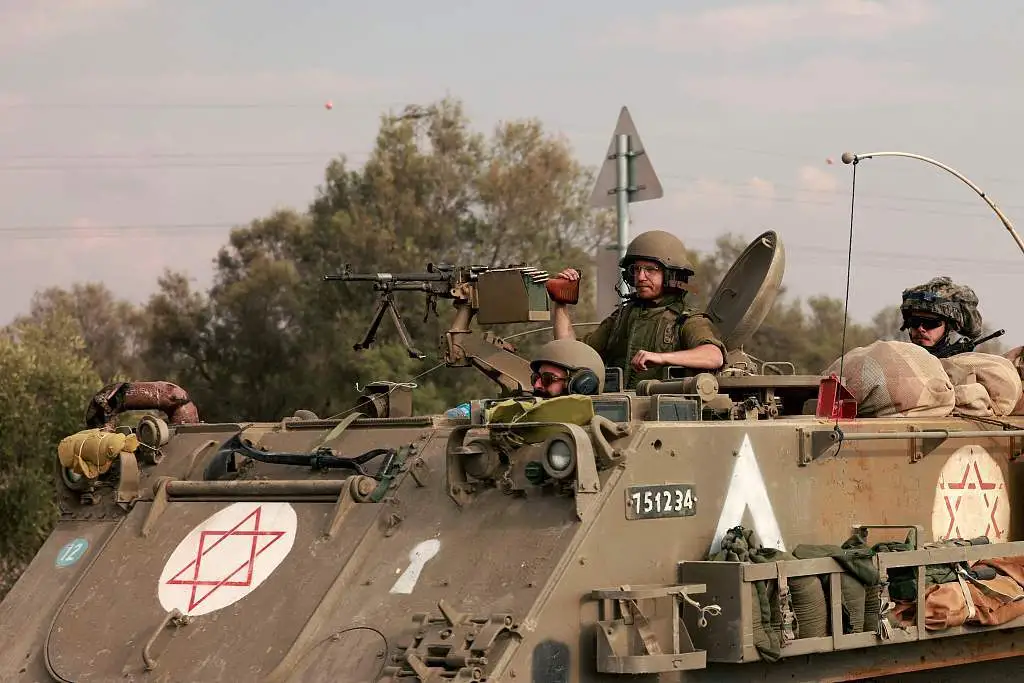 当地时间2023年10月16日，以色列士兵驾驶装甲车驶向加沙地带边境。视觉中国 图