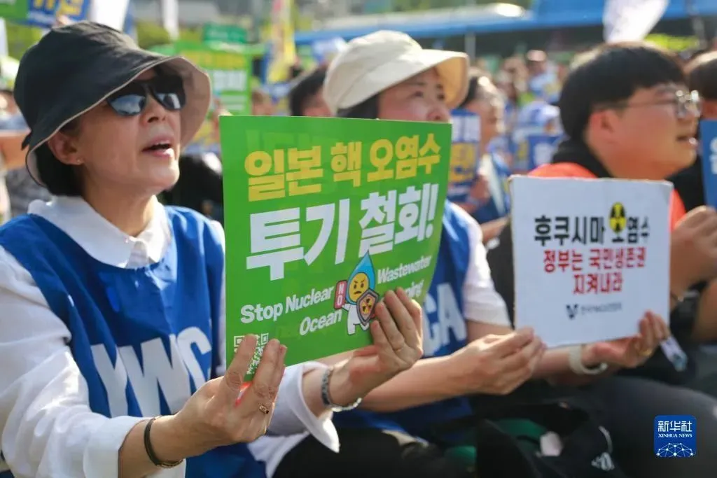 9月2日，人们手持标语在韩国首尔光化门广场集会抗议日本核污染水排海。图源：新华社