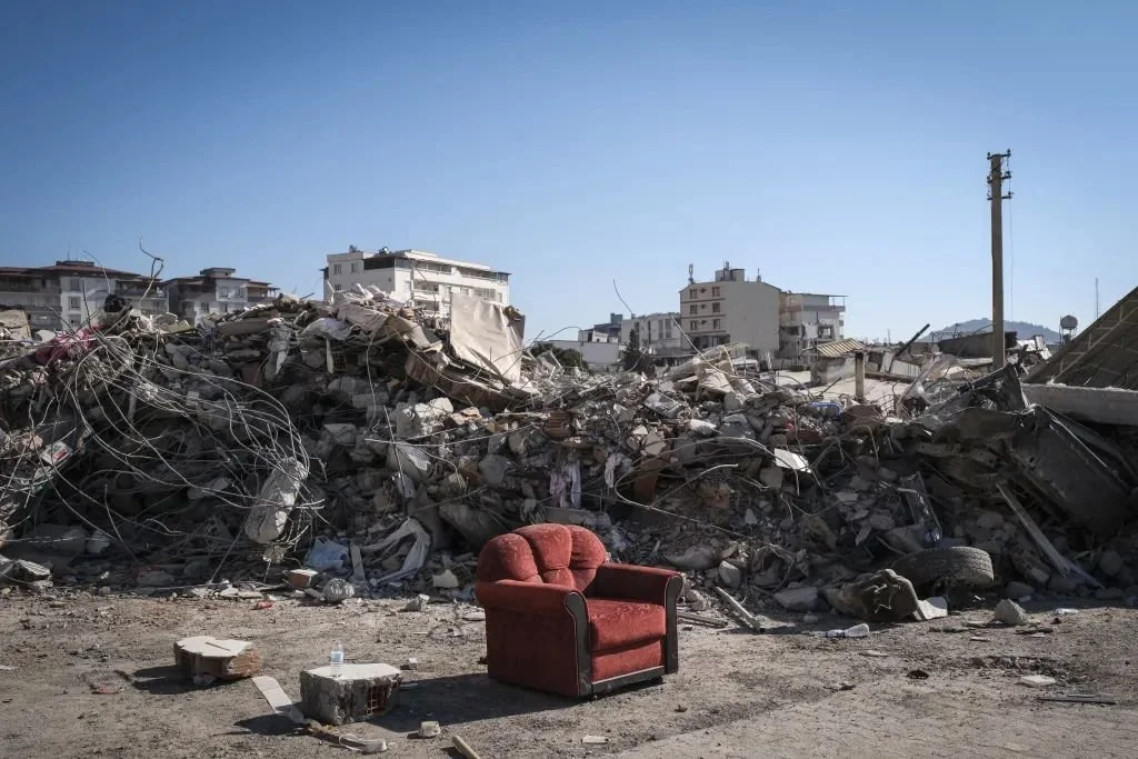 當地時間2023年2月13日，土耳其努爾達吉，一座倒塌的建筑前，一把扶手椅矗立。圖/視覺中國