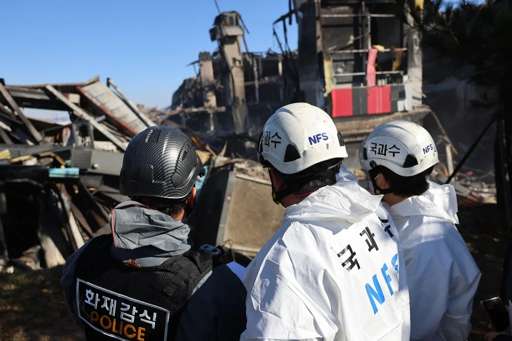 当地时间2025年11月21日，韩国忠清南道天安市，消防、警察、国立科学搜查研究院等联合调查组人员对时尚物流中心火灾现场进行调查。视觉中国 图