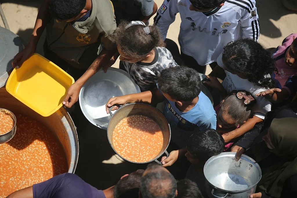 7月29日，加沙地带代尔拜拉赫，一家慈善机构正在分发食物。（视觉中国）