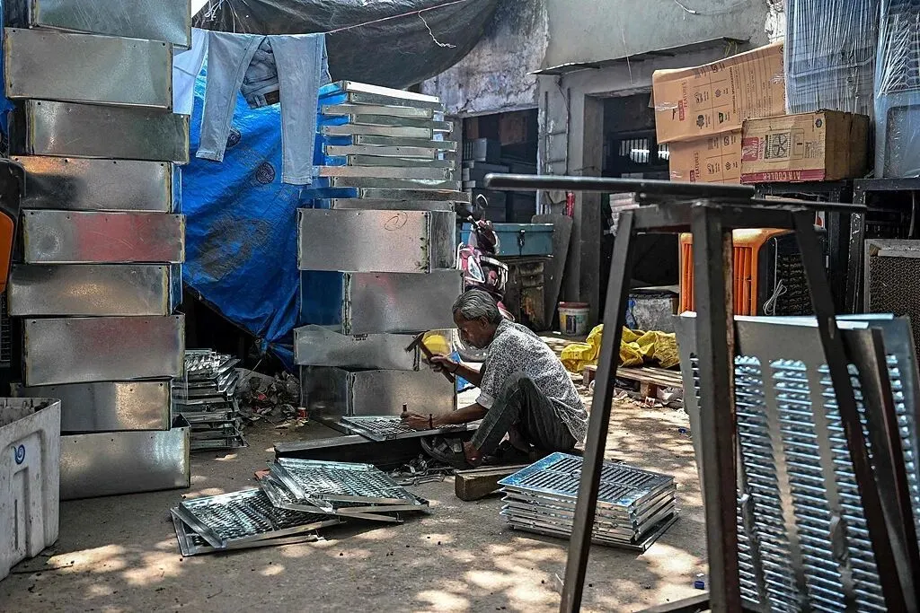 印度一名工人在老城区市场制作空调部件