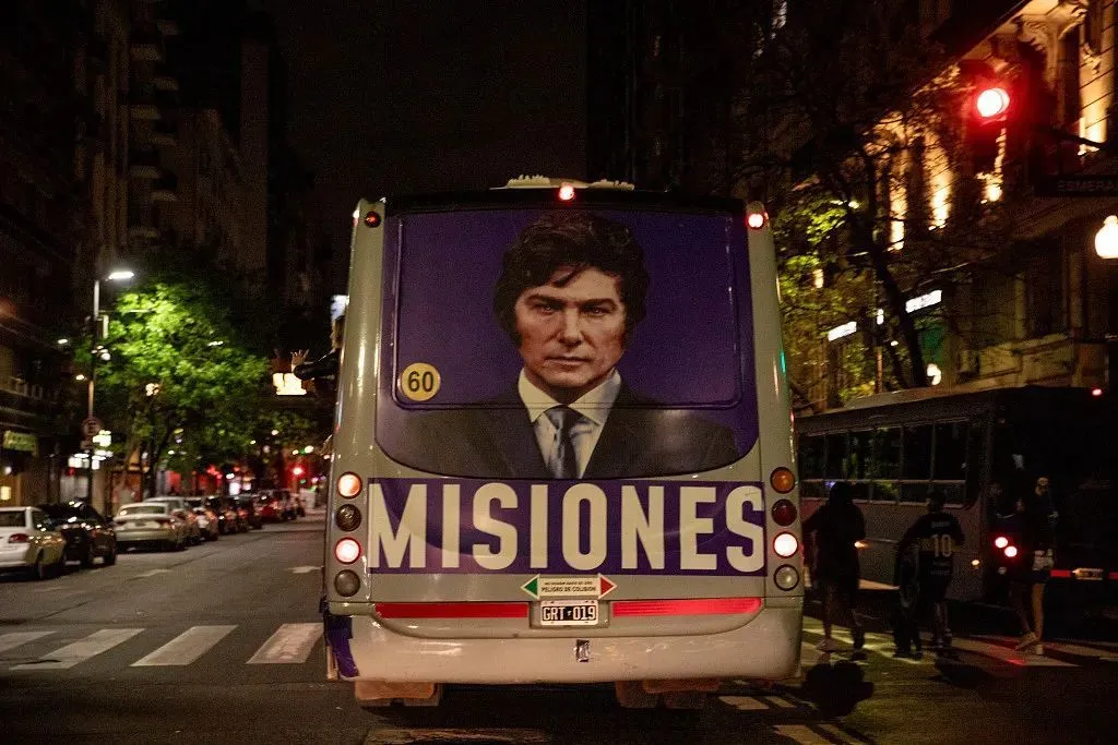▎时为阿根廷总统候选人米莱的支持者在该党总部外举行的选举之夜集会上乘坐公交车。