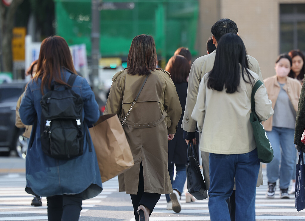 当地时间2023年10月18日，韩国首尔，市民们穿着厚衣服在光化门广场出行。（图源 视觉中国）