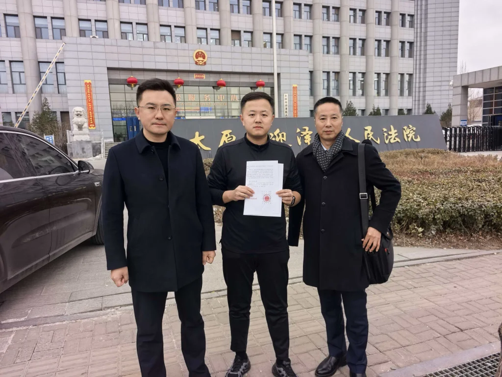 张坤宇(中)和辩护律师李金宝(左)、李长青(右)。