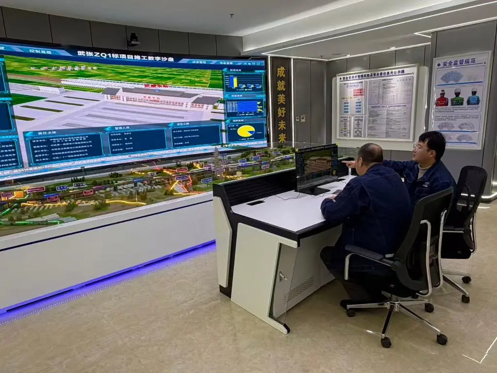 中铁二十一局集团有限公司技术员秦振琦正在教团队中的老师傅操作智慧管理平台　新华社记者　李杰　摄