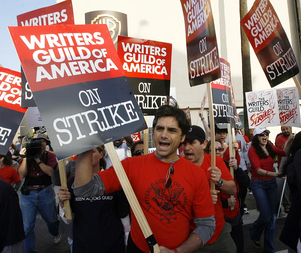 当地时间2007年11月6日，美国洛杉矶，在华纳兄弟电视演播室外，获得艾美奖的医疗剧《急诊室的故事》的演员约翰·斯塔莫斯(中)和其他演员支持美国编剧协会的成员举行罢工。