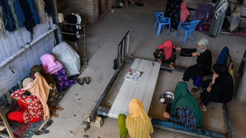 当地时间2023年8月10日，阿富汗马扎里沙里夫，妇女在织地毯。 视觉中国 图