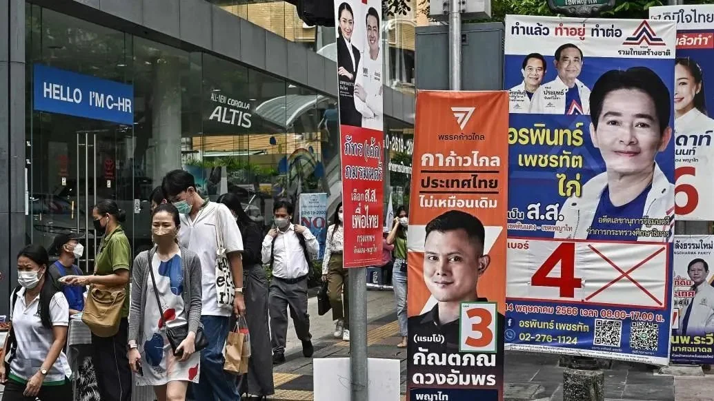 当地时间2023年5月10日，泰国曼谷，泰国大选在即，人们走过曼谷街头各种政党的竞选横幅。视觉中国 图