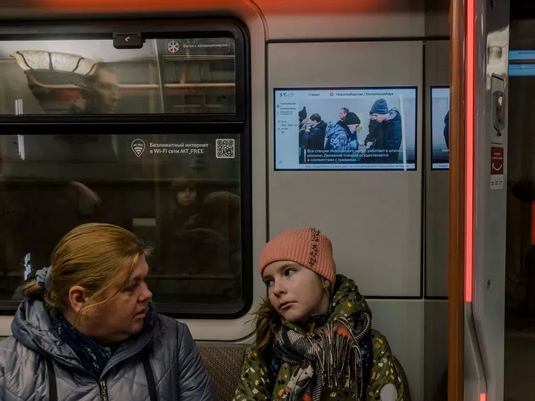 ◆3月23日，莫斯科地铁上的乘客。地铁列车的屏幕在袭击发生后显示着安全指南。