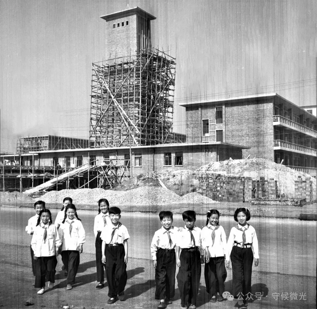 1954年，北京复兴门外，“六一”儿童节前，大水车胡同小学的少先队员们参观正在建设中的儿童医院。一年后的1955年6月1日，北京儿童医院正式落成，是当时全国最大的儿童医院，有600张病床，门诊可达每日千人次。医院的病房全部朝南，背阴部分作为治疗、配餐及处置室等，且每个病房都设有游戏室。贾化民/摄