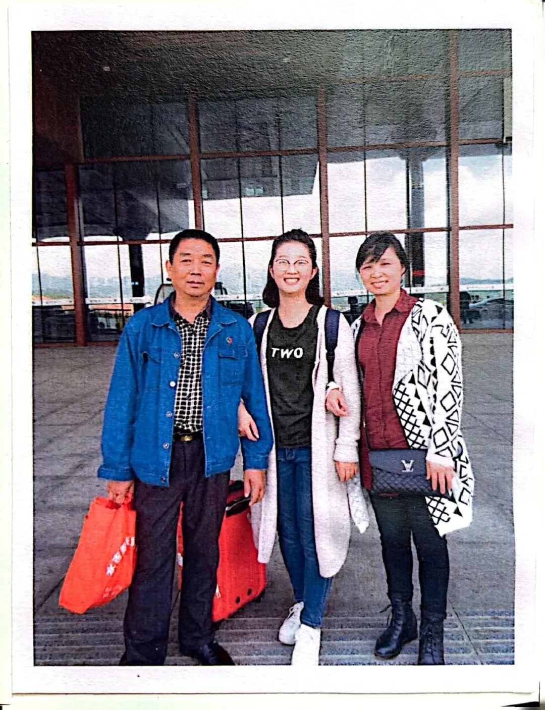 ·章莹颖和父母在高铁站告别，留下了他们最后一张合影。范雨莹/摄（翻拍自相册）