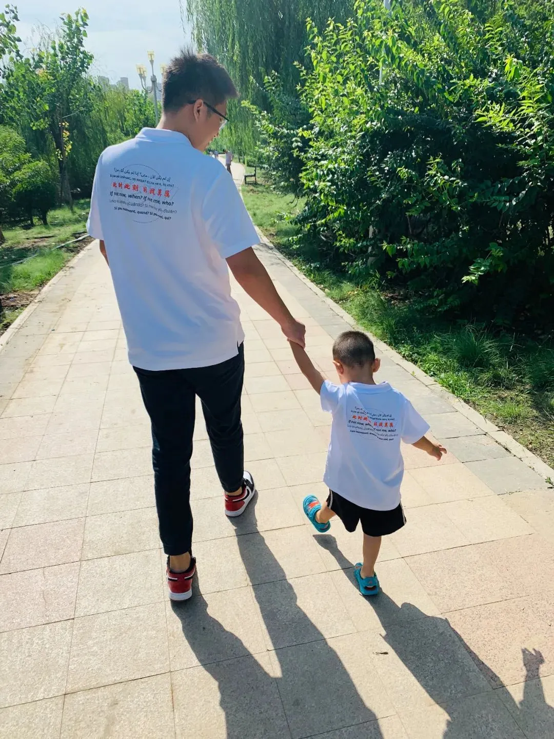 韩龙牵着图图的背影。那一年，图图3岁。