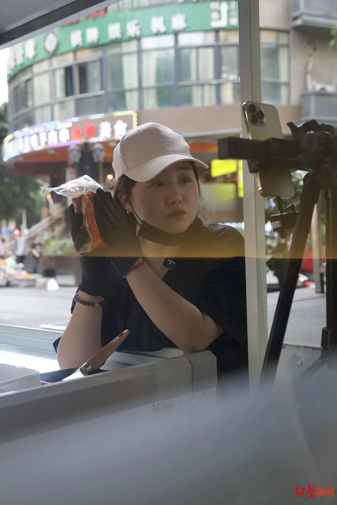 ▲陈美霖边摆摊边直播带货火锅底料